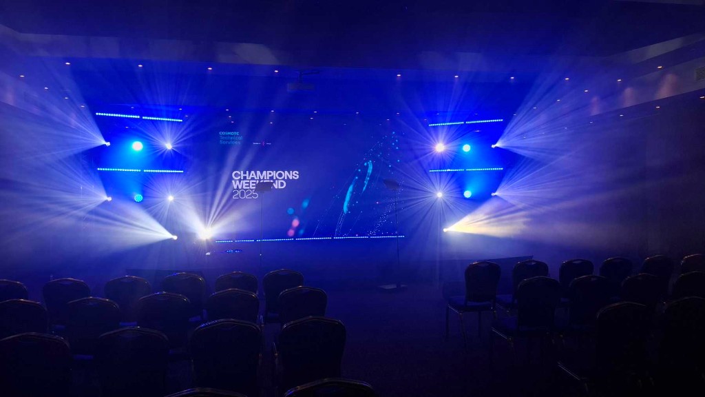 Large LED screen at a corporate event with dramatic stage lighting